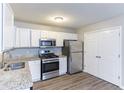 Bright kitchen with stainless steel appliances, granite countertops, and white cabinetry at 5193 Seaside Ct, Atlanta, GA 30349