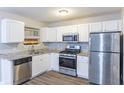 Bright kitchen with stainless steel appliances, granite countertops, and white cabinetry at 5193 Seaside Ct, Atlanta, GA 30349