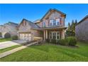 Charming brick home boasts a manicured lawn, two-car garage, and inviting covered front porch at 120 Daniel Creek Ln, Sugar Hill, GA 30518