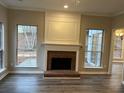 Cozy living room with a brick fireplace and windows offering natural light at 6910 Stone Breeze Dr, Stone Mountain, GA 30087