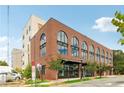 Brick exterior with arched windows showcases architecture, complemented by the building's well-maintained street view at 112 Rogers Ne St # 206, Atlanta, GA 30317