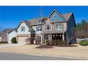 A picturesque two-story home with a mix of brick and siding, complemented by a well-kept lawn at 4280 Hunters Walk Way, Cumming, GA 30028