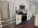 Modern kitchen featuring stainless steel appliances, white cabinets, and dark wood flooring at 2586 Abbotts Glen Dr, Acworth, GA 30101