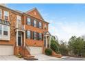 Charming three-story brick townhome boasts a covered entryway, attached garage, and manicured landscaping at 2826 Loftview Sq # 4, Atlanta, GA 30339
