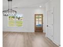 Bright dining space featuring wood floors, wainscotting, a modern chandelier, and a backyard view at 3555 New Hope Rd, Dacula, GA 30019