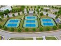 Aerial view of well-maintained tennis courts in a community setting surrounded by lush greenery at 71 Colonial Terrace, Villa Rica, GA 30180