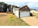Well-maintained home featuring stone accents, a two-car garage, and a spacious backyard at 125 Whistle Way, Locust Grove, GA 30248