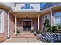 Inviting covered front porch with double doors, brickwork, and decorative plants at 190 Winford Close, Duluth, GA 30097