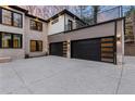 Spacious three-car garage with black paneled doors and sleek, modern design accents at 240 Grogans Lake Pt, Sandy Springs, GA 30350