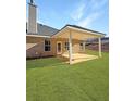 Inviting covered patio with a well-maintained lawn and brick exterior detail at 5301 Tuscany Dr, Douglasville, GA 30135