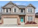 Beautiful two-story home with brick and siding, a two-car garage, and a bright teal front door at 520 Ballyshannon Dr, Dacula, GA 30019