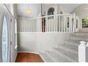Bright foyer with stairs, high ceilings, white railing, and hardwood floors, creating an inviting entrance at 74 Rotunda Ct, Dallas, GA 30157