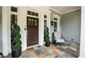 Close up of covered front porch with decorative plants and a chair for relaxation at 3045 Camp Branch Rd, Buford, GA 30519