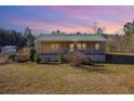 Charming exterior featuring a covered porch and a metal roof, set on a large lot with mature trees at 511 Monroe Cole Rd, Dallas, GA 30157