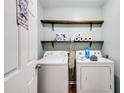 Laundry room with washer, dryer, shelving and natural colored laminate flooring for convenience at 511 Monroe Cole Rd, Dallas, GA 30157
