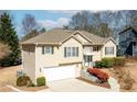 Attractive home featuring vinyl siding, attached garage, manicured hedges, and a stone entryway at 1800 Rockdale Cir, Snellville, GA 30078