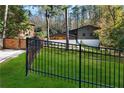 View of home showcasing its modern architectural style, a gated entrance, and a well-maintained lawn at 2751 Margaret Mitchell Nw Dr, Atlanta, GA 30327