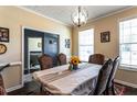 Traditional dining room with a stylish chandelier, large window, and seating for six around the dining table at 935 Sunset Ridge Ln, Lawrenceville, GA 30045