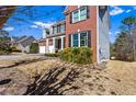 Side view of a brick home with lush greenery, large windows, and an attached three-car garage at 935 Sunset Ridge Ln, Lawrenceville, GA 30045