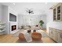 Sunlit living room features a fireplace, built-in shelves, neutral palette furniture, and a modern ceiling fan at 245 Mayfair Ct, Alpharetta, GA 30009
