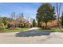 Beautiful home showcasing a circular driveway, lush landscaping, and a grand entrance at 5640 Copper Creek Pass, Cumming, GA 30040