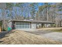 Single-story home featuring a large garage with decorative glass doors and ample parking in the driveway at 5890 Kayron Dr, Atlanta, GA 30328