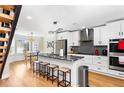 Modern kitchen with stainless steel appliances, gray granite countertops, a large island with seating, and stylish lighting at 6604 Destiny Se Dr, Mableton, GA 30126