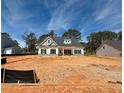 New home with neutral siding, dark shutters, and a covered front porch at 1471 Stephens View Dr, Loganville, GA 30052