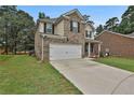 Charming two-story home with brick and tan siding, front lawn, and two-car garage at 212 Long Dr, Mcdonough, GA 30253