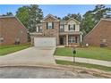Charming two-story home with brick and tan siding, front lawn, and two-car garage at 212 Long Dr, Mcdonough, GA 30253