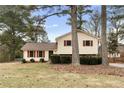 A home with a spacious lawn and red shutters, partially obscured by trees at 2696 Titon Way, Lawrenceville, GA 30044