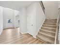 Inviting entryway featuring wood-look floors, staircase, and ample natural light at 3603 Squires Park Ln, Loganville, GA 30052