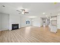 Open-concept living room with a fireplace, wood floors, and a ceiling fan at 1461 Stephens View Dr, Loganville, GA 30052