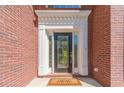 Elegant brick home with a front door featuring decorative glass and white trim, plus a welcome mat at 776 Myerston Ct, Lawrenceville, GA 30044