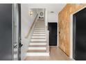 Inviting entryway featuring hardwood floors, a wooden accent wall, and a staircase with white risers at 1307 Glenwood Se Ave, Atlanta, GA 30316