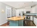 Bright, modern kitchen with a large island, white cabinets, stainless steel appliances, and hardwood floors at 24 Rockland Pl, Decatur, GA 30030