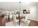 Dining area with an open-concept layout, hardwood floors, and stylish lighting fixtures at 3538 Davenport Rd, Duluth, GA 30096