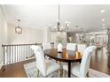 Dining area featuring hardwood floors, an elegant chandelier, and views of the open-concept kitchen at 3538 Davenport Rd, Duluth, GA 30096