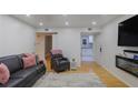 Inviting living room with a black sofa, hardwood floors, and an open doorway to the kitchen at 5600 Kingsport Dr, Atlanta, GA 30342
