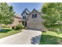 Beautifully landscaped home with a well-maintained lawn, features a stone facade and a driveway leading to a two-car garage at 607 Leland Pkwy, Cumming, GA 30041