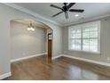 Bright living room with hardwood floors, arched doorway, and a ceiling fan at 607 Leland Pkwy, Cumming, GA 30041