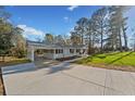 Wide view of home from the driveway, carport, and landscaping. Lots of parking and space for entertaining at 3784 Robinson Ne Rd, Marietta, GA 30068