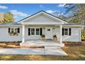 Inviting front porch with white columns and black shuttered windows accents a beautifully landscaped yard at 3784 Robinson Ne Rd, Marietta, GA 30068