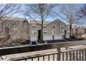 Multi-story townhome complex with grey siding, attached garages, mature trees, and private balconies at 4254 River Green Nw Dr # 611, Atlanta, GA 30327