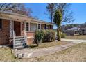 Traditional brick home with a small porch, landscaping and a concrete walkway at 1210 Stoneybrook Rd, Forest Park, GA 30297