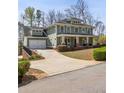 View of the house from the side showcasing the garage, driveway, and surrounding landscaping at 1865 Butlers Ln, Decatur, GA 30033