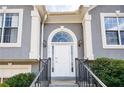 Close up of the front door with an arched window, decorative columns and black railings at 4170 Hopkins Bluff Way, Duluth, GA 30096