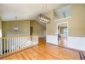 Open foyer area with hardwood floors, staircase, white wainscotting and modern light fixtures at 4170 Hopkins Bluff Way, Duluth, GA 30096