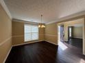 Dining room featuring dark floors, decorative lighting fixture, and adjacent rooms at 675 Paper Creek Dr, Lawrenceville, GA 30046