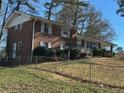 A charming brick home featuring white window shutters, a manicured yard, and a secure chain-link fence at 2977 Appling Dr, Atlanta, GA 30341